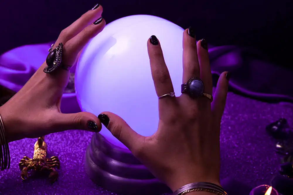 M&atilde;os sobre uma esfera de cristal iluminada